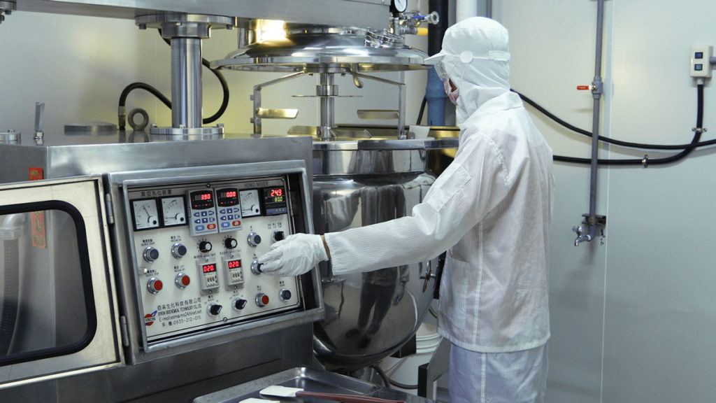 Technician in the factory at the creams mixing station